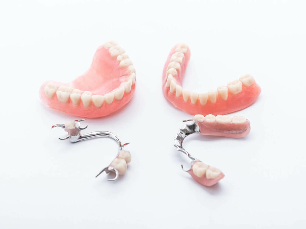 Full, partial and snap on dentures sitting on table