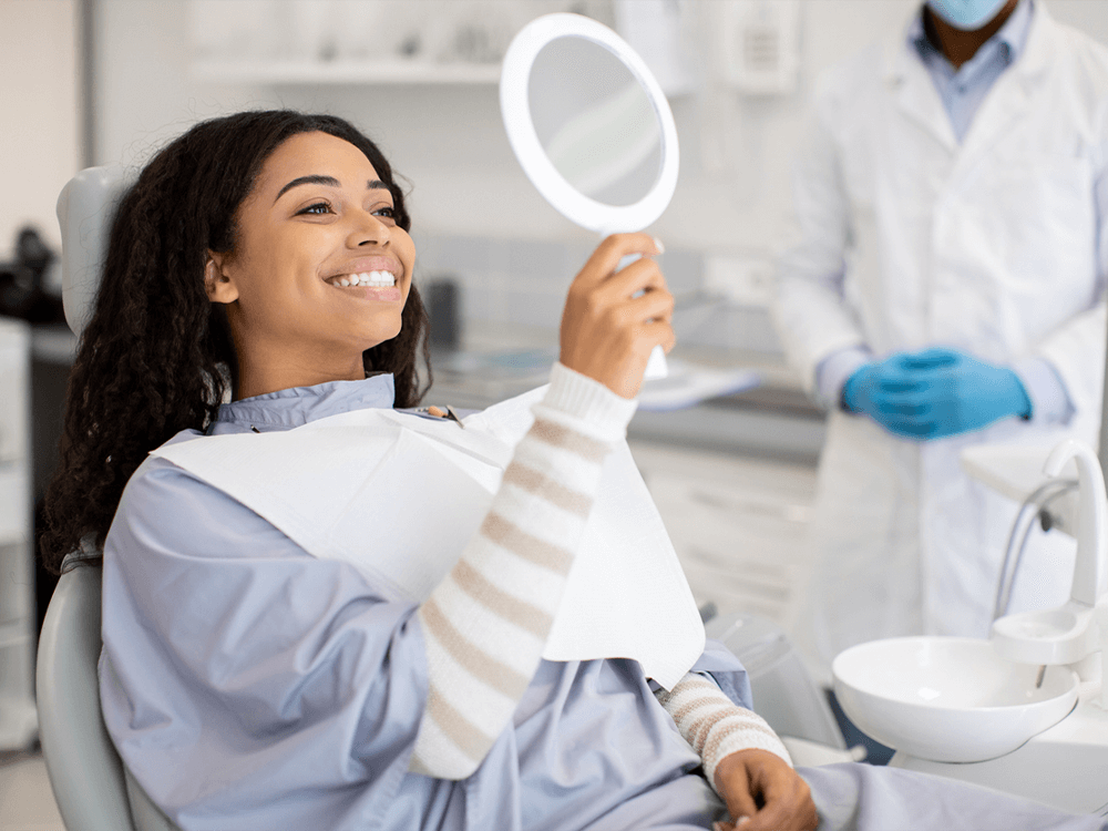 Woman smiling looking at her teeth after a dental appointment